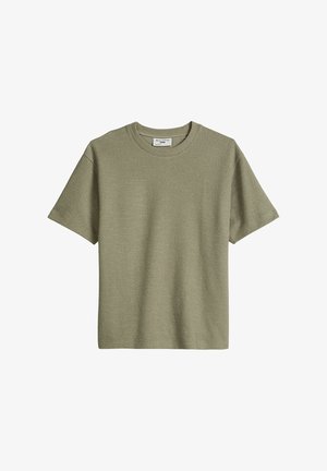 Short-sleeve crewneck t-shirt in light olive green with textured fabric and a small brand label inside the neckline.