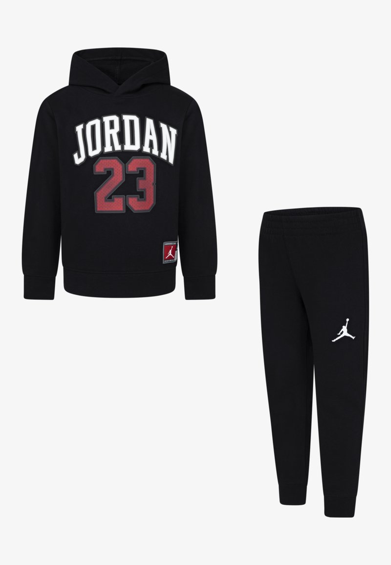 Ensemble de sweat à capuche et pantalon noirs. Le sweat à capuche présente un graphisme "JORDAN 23" en blanc et rouge. Le pantalon a un logo Jumpman blanc ; les deux sont en tissu doux.