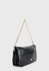 Bolso de mano de imitación cuero negro con superficie texturizada, cadena dorada y un sutil acento de logo en la parte frontal. Forma rectangular.
