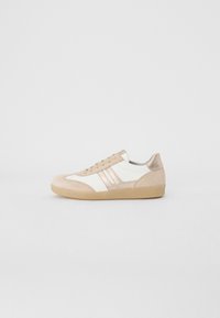 Sneakers beige e bianchi realizzati in materiali scamosciati e in pelle. Presentano una punta arrotondata, un design con lacci e una suola in gomma testurizzata.