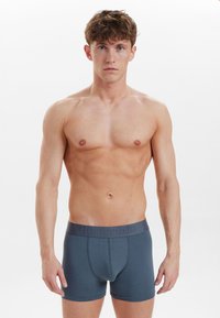 Men's dark gray boxer briefs made from soft fabric, featuring a logo waistband and a fitted shape with a smooth finish and no visible patterns.