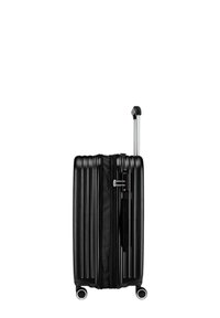 Valigia rigida nera con scanalature verticali, manico in alluminio retrattile e quattro ruote per la mobilità. Chiusura con zip e lucchetto laterale.