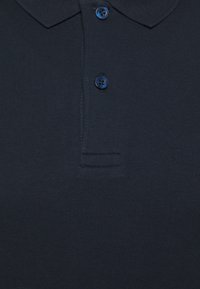 Mörkblå pikétröja i mjuk bomull, med en treknappars placket, standardkrage och en subtil, slät textur.