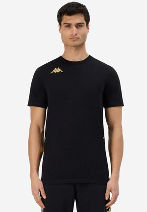 T-shirt nero a maniche corte realizzato in tessuto morbido, con un logo dorato sul lato sinistro del petto e dettagli laterali dello stesso colore.