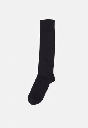 Schwarze Kniestrümpfe aus glattem, dehnbarem Stoff mit einem gerippten oberen Rand und einem verstärkten Zehenbereich. Keine sichtbaren Muster oder Akzente.