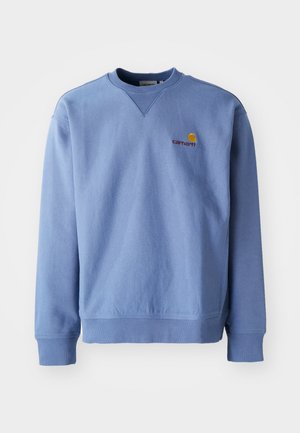 Modrá mikina s okrúhlym výstrihom, ribbovanými manžetami a spodným lemom, a malým vyšitým logom na hrudi. Vyrobená z mäkkej, textúrovanej tkaniny.