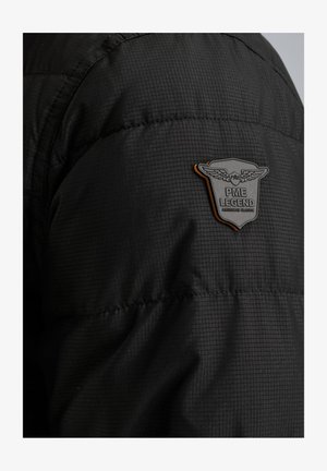 Black puffer jacket featuring a textured fabric, quilted design, and a shield-shaped PME Legend logo on the left shoulder.