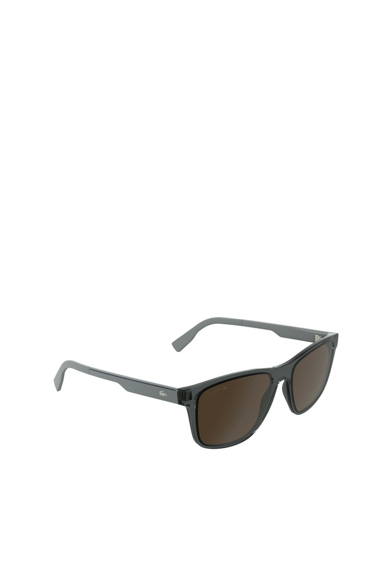 Sunglasses with black plastic frames, brown tinted lenses, angular design, and Lacoste logo on the temple. Sleek and modern appearance.