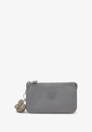 Grijze nylon ritstasje met een rond logo, een textuur oppervlak en een pluizige charme bevestigd aan de ritssluiting.