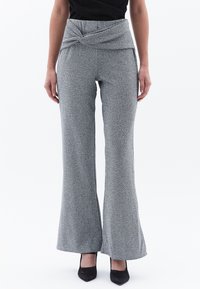 Grijze flared broek met een gedraaide taillebanddetail, gemaakt van een tonige stof, met een subtiel patroon en een lichte glans.