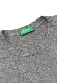 Šedý pletený svetr s kulatým výstřihem, vyrobený z texturované látky. Obsahuje zelenou etiketu s nápisem "United Colors of Benetton."