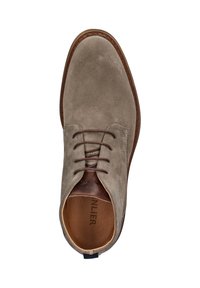 Beige suède leren veterschoenen met een bruine zool en een gewatteerde tan binnenkraag, bekeken van bovenaf.