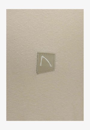 Beige kangas, millel on tekstuuriline pind, sisaldab heledamas beežis ristküliku kujulist logopatchi, millel on minimalistlik valge disain embosseeritud.