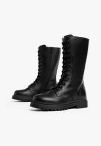 Black leather knee-high boots with a lace-up front, side zipper, and textured rubber sole. Features smooth finish and sturdy construction.