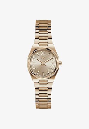 Kullatooni käekell tekstuurse sihverplaadi, Rooma numbriga XII, pulgakujuliste tunniindeksite, kolme osutiga ja metallist lingitud rihmaga.