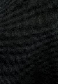 Sort tekstureret stof med tæt vævning, der viser et diskret mønster. Overfladen virker holdbar og glat og har en ensartet farve.