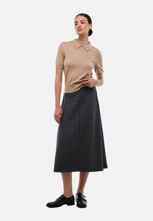 Top en tricot beige à manches courtes avec un col, associé à une jupe midi en laine gris foncé et des chaussures en cuir noires.