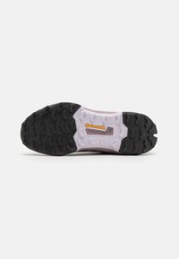 Schwarze und helllila Sportschuhsohle mit tiefen Profiltiefen, ausgestattet mit einem strukturierten Muster und einem sichtbaren "Continental"-Logo in der Zwischensohle.