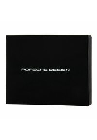 Caja rectangular negra con acabado mate, que presenta el texto "PORSCHE DESIGN" en blanco, centrado en la parte frontal.
