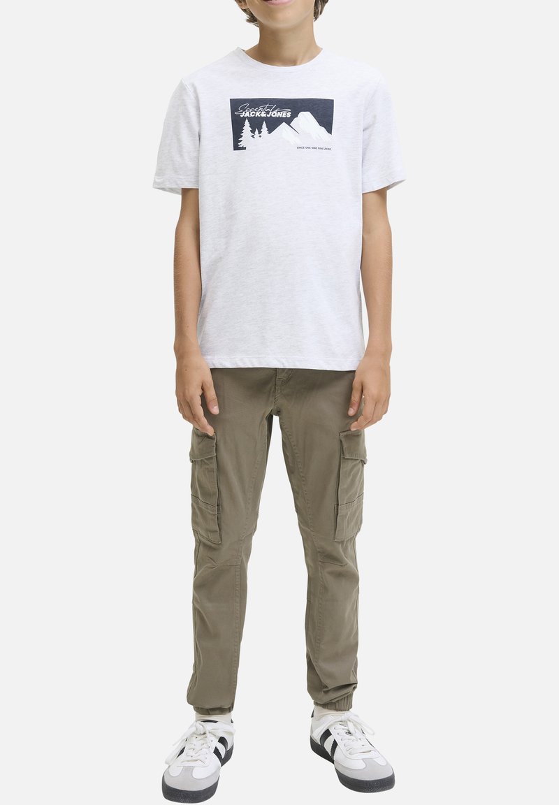 T-shirt blanc à manches courtes avec un graphique de montagne, associé à un pantalon cargo vert olive avec des poches latérales et une coupe décontractée.