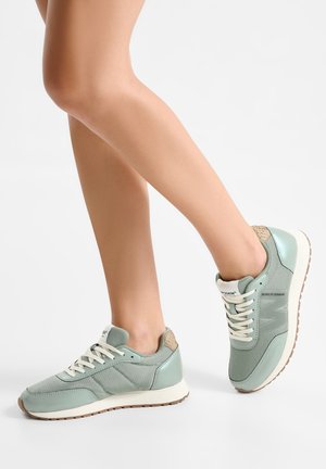 Lichtgroene sneakers met een afgeronde neus, een bovenwerk van mesh, crèmekleurige veters en een getextureerde beige accent aan de hiel. Rubberen zool met bruin profiel.