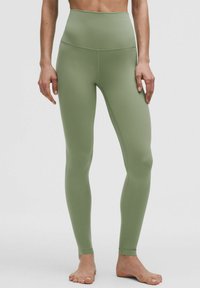 Legginsy w kolorze oliwkowym, wysoko osadzone w talii, wykonane z elastycznej tkaniny. Posiadają gładki, płaski pas i zwężające się nogawki. Bez widocznych logo czy wzorów.