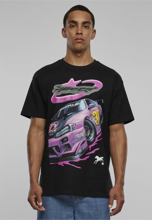 Junger Mann trägt ein schwarzes T-Shirt mit einem großen pinkfarbenen Rennwagen-Grafik und der Nummer 30, kombiniert mit blauen Jeans.