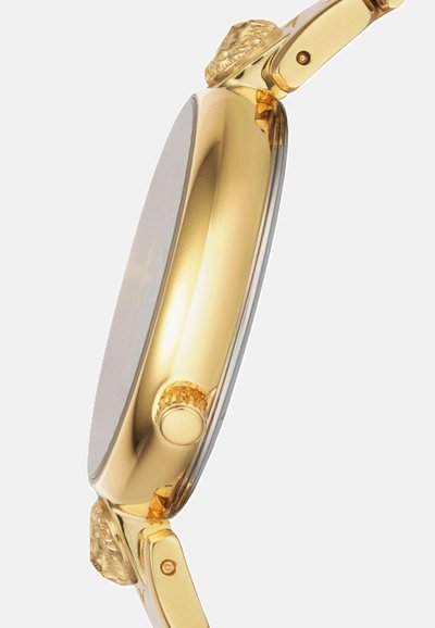 Gold-tone metal wristwatch featuring a smooth, oval case, raised lion detail on the crown, and a polished, reflective band.