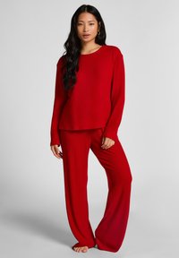 Rood geribbelde gebreide lounge set met een losse lange mouw top en wijde broekspijpen. Zachte textuur met een ontspannen silhouet.