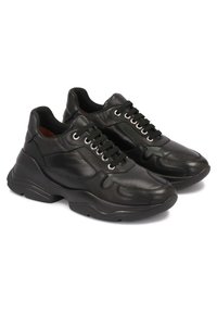 Černé kožené tenisky s masivní podrážkou, zavazováním na tkaničky, zakřivenými detaily a kovovými průchodkami. Hladká textura a zaoblený tvar špičky.