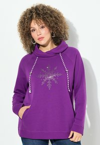 Felpa viola con cappuccio e collo a cowl, caratterizzata da un design di fiocco di neve in strass, con cordini bianchi e tasche frontali.