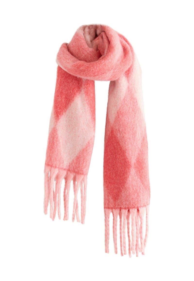 Mjuk rosa och korallfärgad ullsjal med stort diamantmönster och fransade ändar, vikt och hängande mot en vit bakgrund.