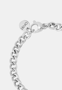 Bracciale in argento con maglie intrecciate, chiusura a gancio e un charm rotondo con inciso "LIU·JO". Texture metallica liscia.