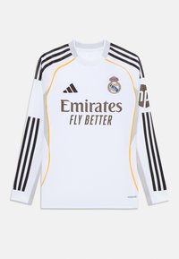 Maillot de football à manches longues blanc avec des accents noirs et jaunes, arborant le logo "Emirates Fly Better", le blason du club et trois bandes noires sur les manches.