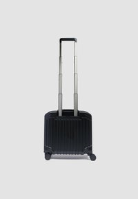 Hartschalen-Handgepäckkoffer in Schwarz mit vertikalen Rillen, ausziehbarem silbernen Griff und vier Rollen für Mobilität.