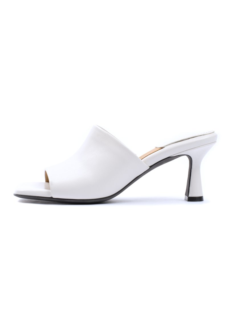 Mulo bianco open-toe con tomaia in pelle liscia e curva e tacco sottile e inclinato in nero, caratterizzato da un design minimalista.