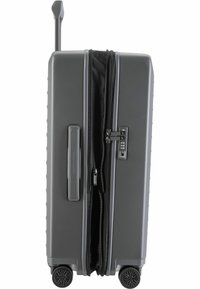 Maleta gris de carcasa dura con asa retractable, cierre de cremallera, cerradura combinada y cuatro ruedas para movilidad. Interior forrado con tela negra.