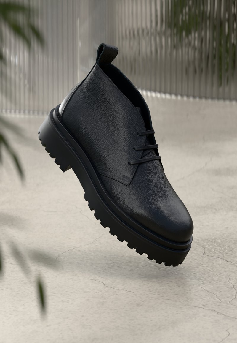 Schwarze Leder-Stiefelette mit strukturiertem Obermaterial, Schnürdesign und klobiger Gummisohle mit tiefem Profil für besseren Halt.