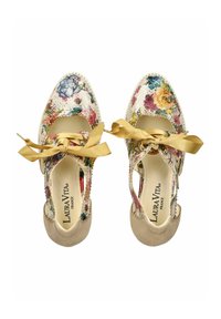 Zapatos con un patrón floral, base blanca, acentos beige y cintas de satén doradas. Diseño abierto con detalles texturizados y punta redondeada.