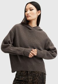 Felpa con cappuccio di colore marrone scuro, realizzata a maglia con polsini e orlo a coste, caratterizzata da una vestibilità comoda e una consistenza morbida. Abbinata a pantaloni con stampa leopardata.