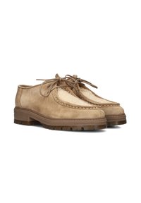 Suede shoes with a beige upper, featuring a plush, cream-colored textile panel, lace closures, and a thick, textured rubber sole.