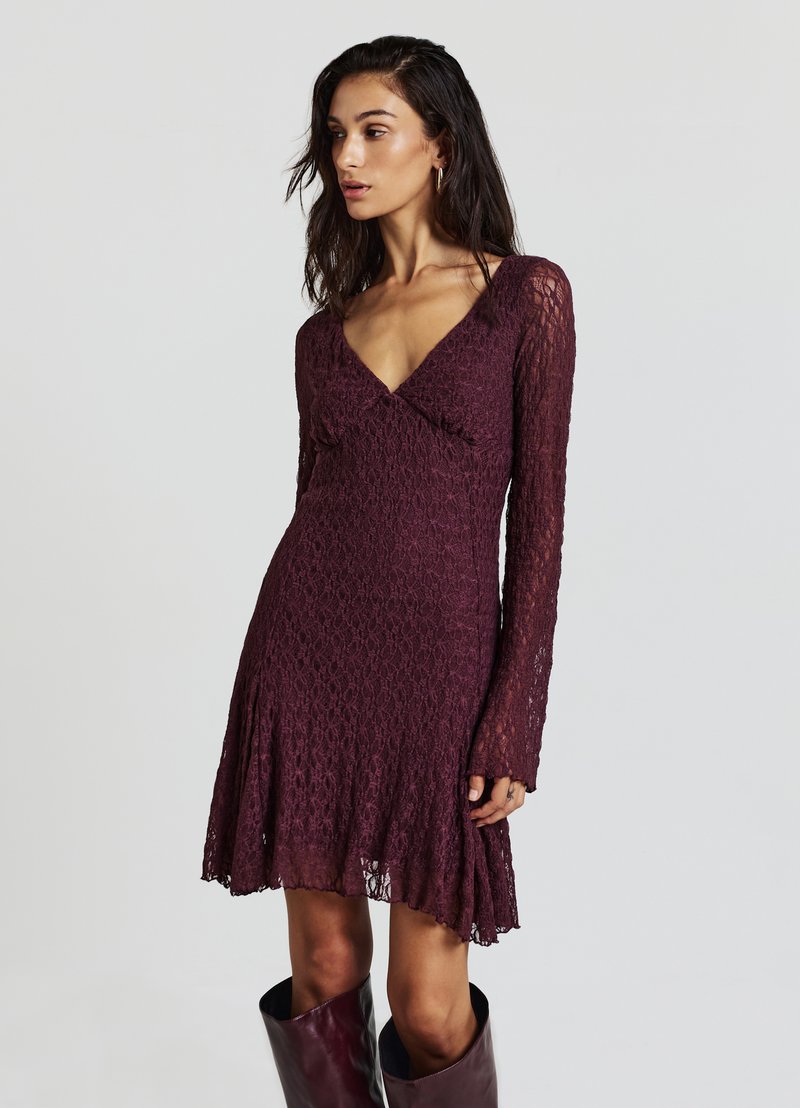 Spitzenkleid in Pflaumenfarbe mit langen Ärmeln, V-Ausschnitt und ausgestelltem Rock. Verfügt über filigrane Muster und eine leichte Textur.
