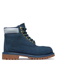 Botín de ante azul marino con cuello acolchado gris, ojales dorados, cordones verdes y suela de goma marrón con patrones de relieve pronunciados.
