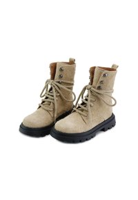 Botas de tobillo de ante beige con puntas redondas, suelas de goma negra y ojales redondos para los cordones. Presentan acentos de cuero marrón y tela texturizada.