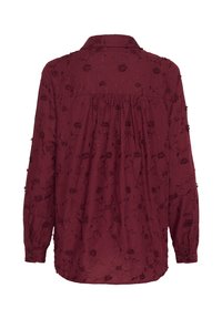 Bordeaux langærmet skjorte med blomsterbroderi, krave og knapmanchetter. Let samlet ryg for en afslappet pasform. Udfordrende tekstur.