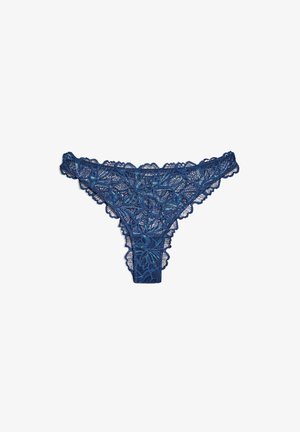Tanga in pizzo blu scuro con motivo floreale, bordi ondulati e texture semitrasparente. Presenta dettagli intricati su tutta la superficie del tessuto.