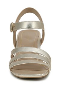 Strappy high-heeled sandal in metallic gold. Features a wide ankle strap with a buckle and a cushioned footbed. Smooth, shiny texture.