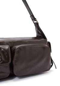 Borsa a spalla in pelle marrone con una texture liscia, dotata di un ampio scomparto e di una tasca frontale più piccola, tracolla regolabile e accessori in oro.