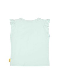 Camiseta de manga corta azul claro con acentos de volantes en los hombros, textura suave y una pequeña etiqueta amarilla en la costura inferior izquierda.