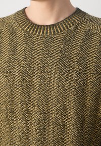Sweter dziany z wzorem jodełki, o teksturowanej powierzchni w kolorze ciemnej zieleni i musztardowej żółci, z prążkowanym dekoltem.